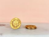 a gold coin sitting next to a stack of gold coins