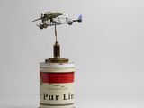 a small tin with a small airplane on top of it