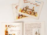 trois livres pour enfants sont ouverts sur une surface blanche