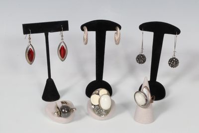 Trois paires de boucles d'oreilles sont présentées sur un présentoir noir