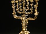 une menorah plaquée or à quatre branches, posée sur un socle en marbre
