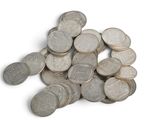 a pile of silver coins on a white surface