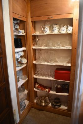 a pantry with a lot of dishes and dishes on the shelves