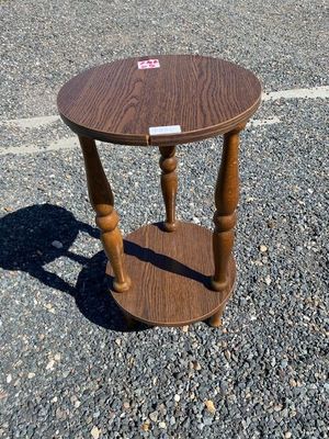 a small wooden table with a sticker on the top of it