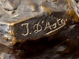 a bronze statue of a dog with a name on it