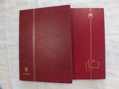 un livre rouge aux bords dorés posé sur un drap blanc