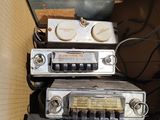 Plusieurs vieilles radios sont empilées les unes sur les autres dans une boîte en carton
