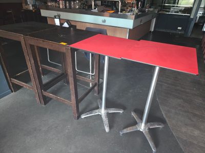 une table rouge et deux tabourets dans une pièce
