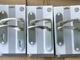 trois poignées métalliques argentées sur une boîte en carton, elle-même placée dans une autre boîte en carton
