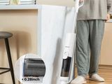 La femme utilise l'aspirateur pour nettoyer le parquet.