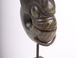 sculpture of a face on a stand on a white background