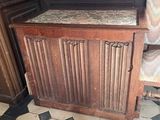 a wooden cabinet and a chair in the corner of a room