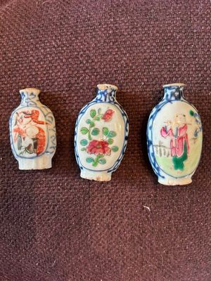 trois petits vases sont alignés sur une surface marron