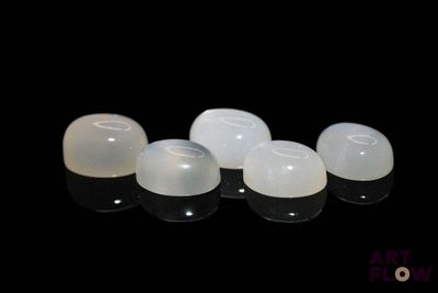 four white plastic eggs sitting next to each other on a black surface