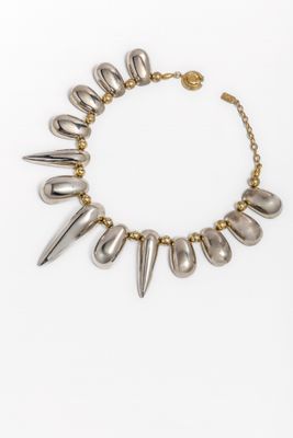 a gold and silver necklace with spikes on a chain