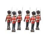 trois figurines de soldats en uniforme rouge tenant des fusils
