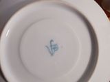 a white plate with a blue flower on it on a table