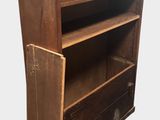 an old wooden bookcase with two drawers on top of it