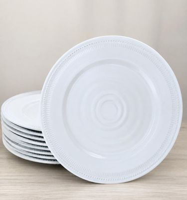 quatre assiettes blanches empilées les unes sur les autres sur une table en bois
