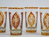 quatre verres à shot sont alignés sur une surface blanche