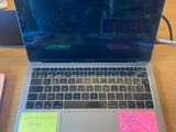 a laptop computer sitting on a desk with sticky notes on the keyboard