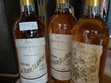 trois bouteilles de vin posées sur une table l'une à côté de l'autre
