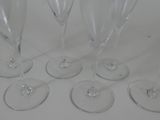 six empty wine glasses sitting on a table with a white background
