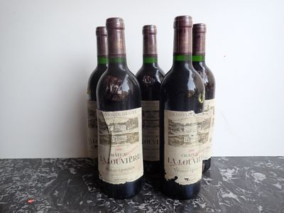 three bottles of wine sitting on top of a table next to a bottle of wine
