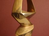 a bronze sculpture of a spiral design on a wooden base