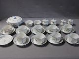un grand nombre de tasses et de soucoupes sur une table