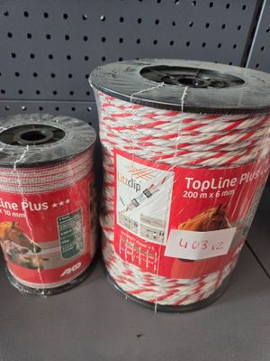 two rolls of red and white bakers twine sitting on a shelf
