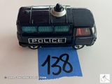 une petite voiture de police miniature posée sur un morceau de papier bleu
