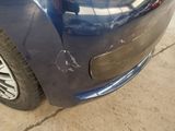 a close up of a blue car with a denting on it
