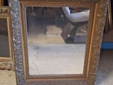 a mirror that is sitting on the floor in front of a chair
