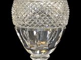 un vase en verre avec un socle doré sur fond noir