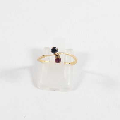 un gros plan d'une bague en or sertie d'une grenat