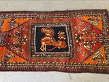 un tapis orange et noir sur lequel figure l'image d'un homme à cheval