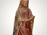 a wooden statue of a woman holding a book