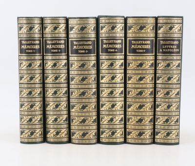 un lot de cinq livres posés sur une surface blanche
