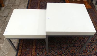 deux tables basses blanches posées sur une moquette recouverte d'un tapis