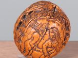 a wooden ball with carvings on it sitting on a table