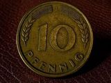 a close up of a ten cent coin on a brown leather surface