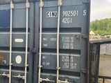 un conteneur bleu posé au bord d'une voie ferrée