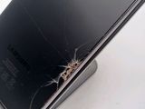 a broken cell phone sitting on top of a stand