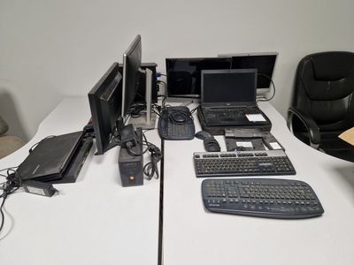 a lot of computers on a desk with a keyboard and a mouse