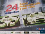 a poster of two racing cars on display in front of a building