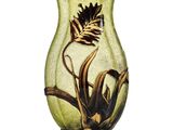 un vase vert orné d'une fleur, posé sur une table