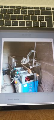 un ordinateur portable posé sur une table, avec une image à l'écran