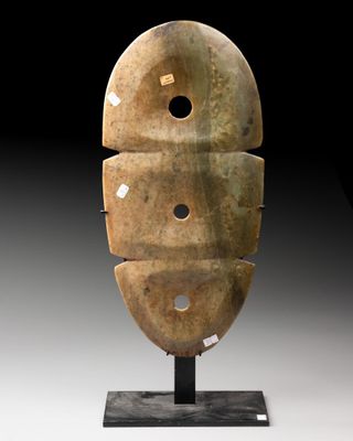une photo d'une sculpture représentant un visage, posée sur un socle