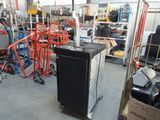 un réfrigérateur noir posé dans une pièce où se trouvent de nombreux autres appareils électroménagers